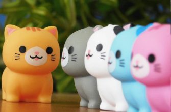 Row of colorful cat figurines with orange one in front