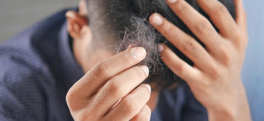 a man is combing his hair with his hands